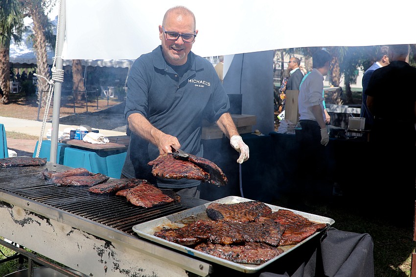 Douglas Noppe from Michael's On East grills flank steaks with a smile.