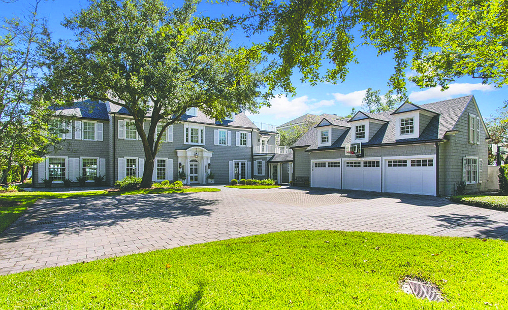 Riverfront three-story home built in 1927 features seven bedrooms, seven full and two half-bathrooms, porches, balconies, outdoor kitchen, pool and dock.