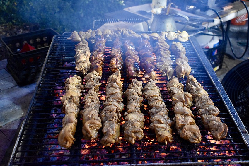 These smoking skewers of meat have people lined up down the street in front of the Filipino Foods stand.