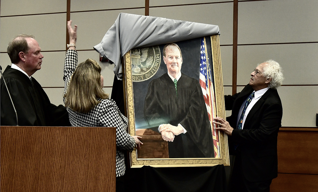 Senior U.S. District Judge Timothy Corrigan watches as his wife, Nancy, and artist Pablo Rivera unveil his official portrait Feb. 21 at the Bryan Simpson U.S. Courthouse.