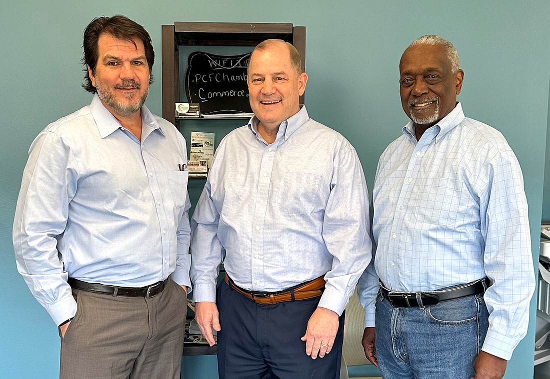 Palm Coast-Flagler Regional Chamber of Commerce Chair Michael Chiumento, newly named President John Phillips and Howard Holley, who served as the Chamber's interim president and CEO for five months. Courtesy photo