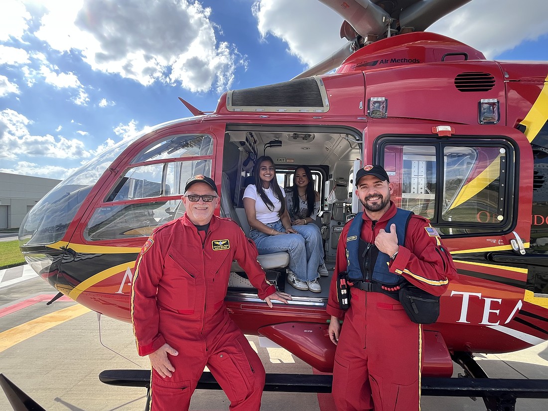 Orlando Health Air Care team members John Campbell, left, and Angel Rios-Peña, right, explained all the equipment on the helicopter to Horizon High School seniors Gia Patel and Valentina Reyes.