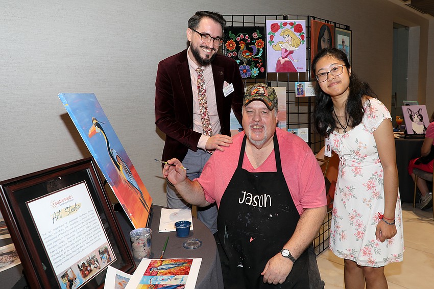 Chris Leverett oversees the art program along with assistant Isabella Martin, and they are photographed with emerging artist Jason Leach.