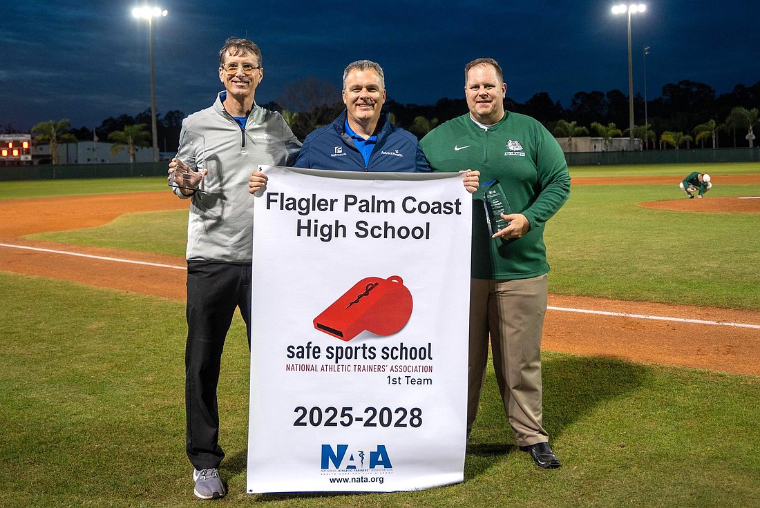 AdventHealth's Erik Nason (center) presents Flagler Palm Coast athletic trainer Ron Steinwehr (left), an AdventHealth team member, and FPC athletic director Scott Drabczyk with the Safe Sport School Award. Photo courtesy of AdventHealth