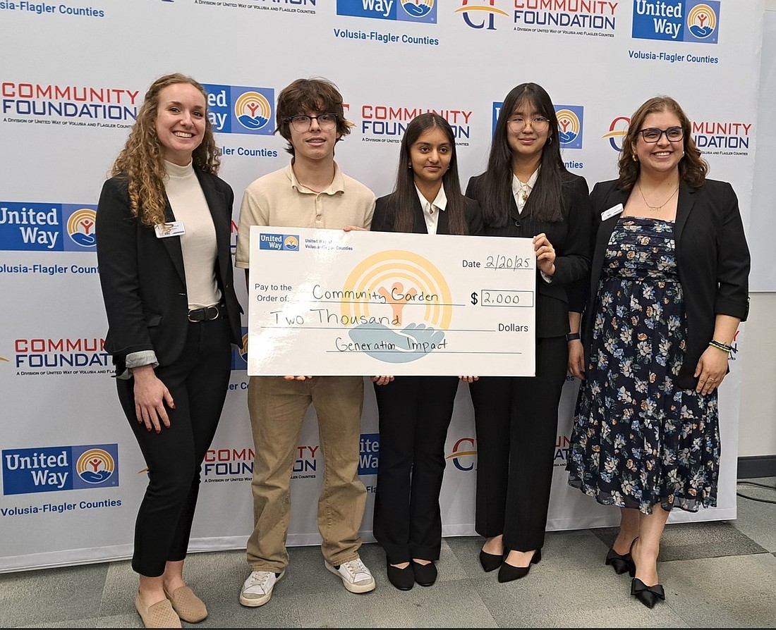 Flagler County students Aasi Bharucha and Elisabeth Chheang of FPC and Lucas Espinoza of Matanzas hold up a check at the Generation Impact Social Innovation Fund pitch competition for their community garden project. With the students are Generation Impact mentors Heather Prasse and Ustina Guirguis. Courtesy photo