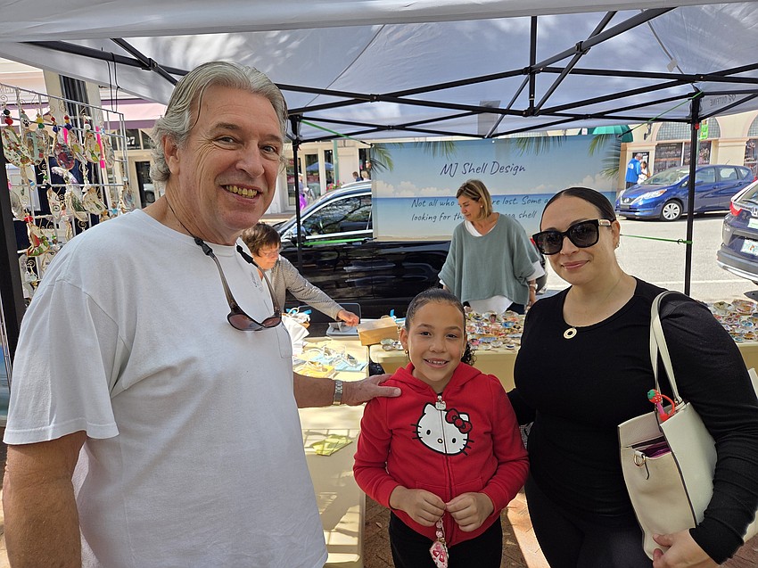 Michael D. Cowgill of Miami, Mia Boyd, center, and her mom Michele Boyd of Ave Maria take in the displays at Le Marche Marketplace.
