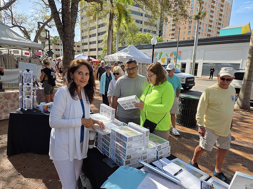 Kris Anderson, right, and Firoz Khan, both from Sarasota admire the works of artist Mary Lou Johnson, left.