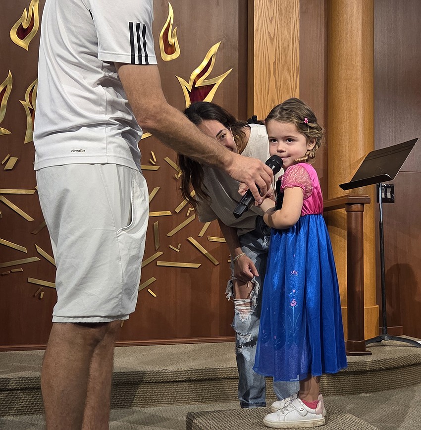 Summer Messner talks about her costume during the kids parade at the Purim Carnival on Sunday.