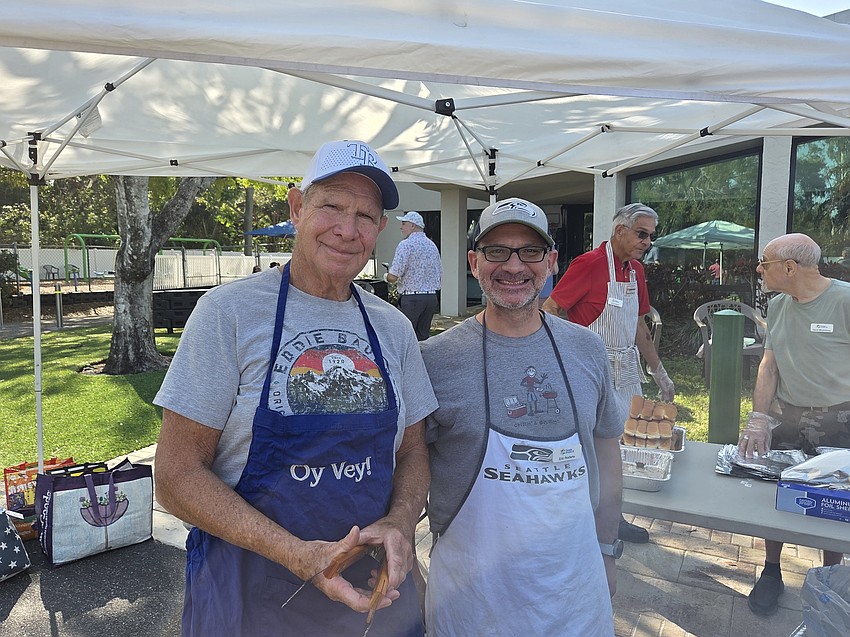 Ken Simon, left, and Eric Rodarte were cooking and serving up hamburgers and hot dogs Sunday at Temple Emanu-El.
