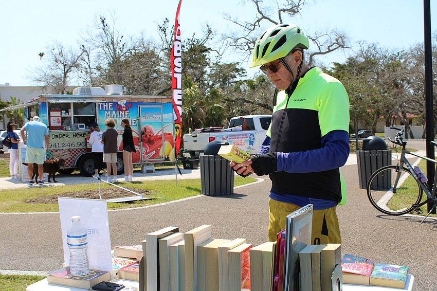 Resident Lenny Nelson, who said he was pleasantly surprised by the community open house, picks up a free book and checks out other local resources.