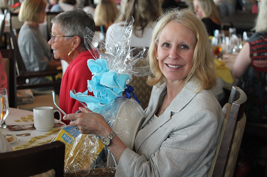 Susan Miller wins a raffle basket to take home from the fashion show.