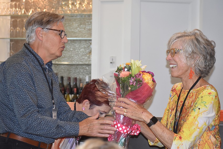 Artist Michael Parkinson presents Deborah Van Brunt with a thank you bouquet for all her hard work.