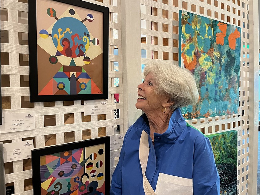 Barbara Romig admires her sister Carol Kluding's acrylic painting, titled 