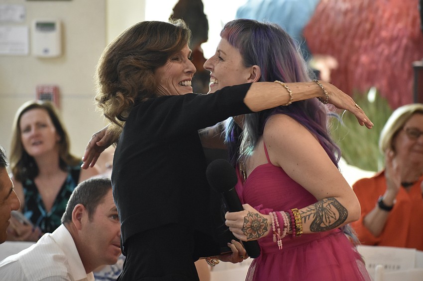 Leslie Travis Howell receives the Best Mom in the Universe Award from her daughter Megan Howell.