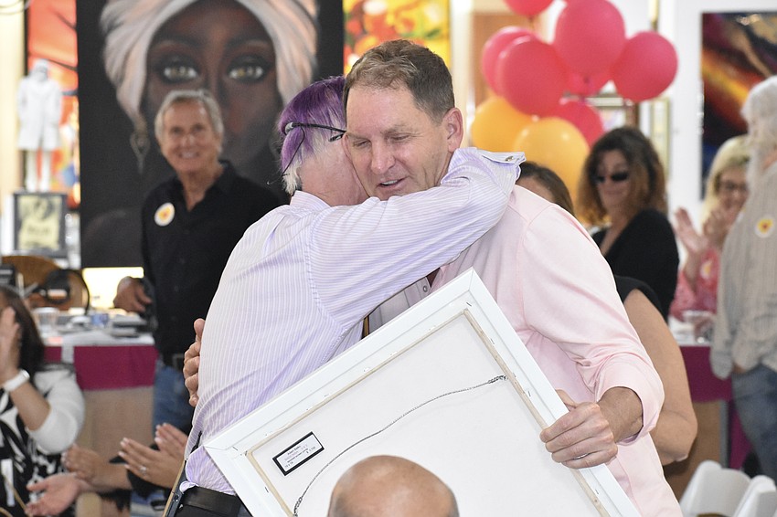 Paul Sykes hugs Dan Dykgraaf, one of the earliest supporters of the auction, whose purchase allowed the auction to reach its goal.
