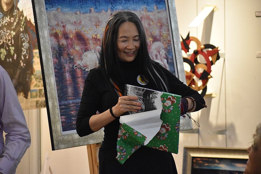 Li Jian Volk opens a copy of a gift, the book 