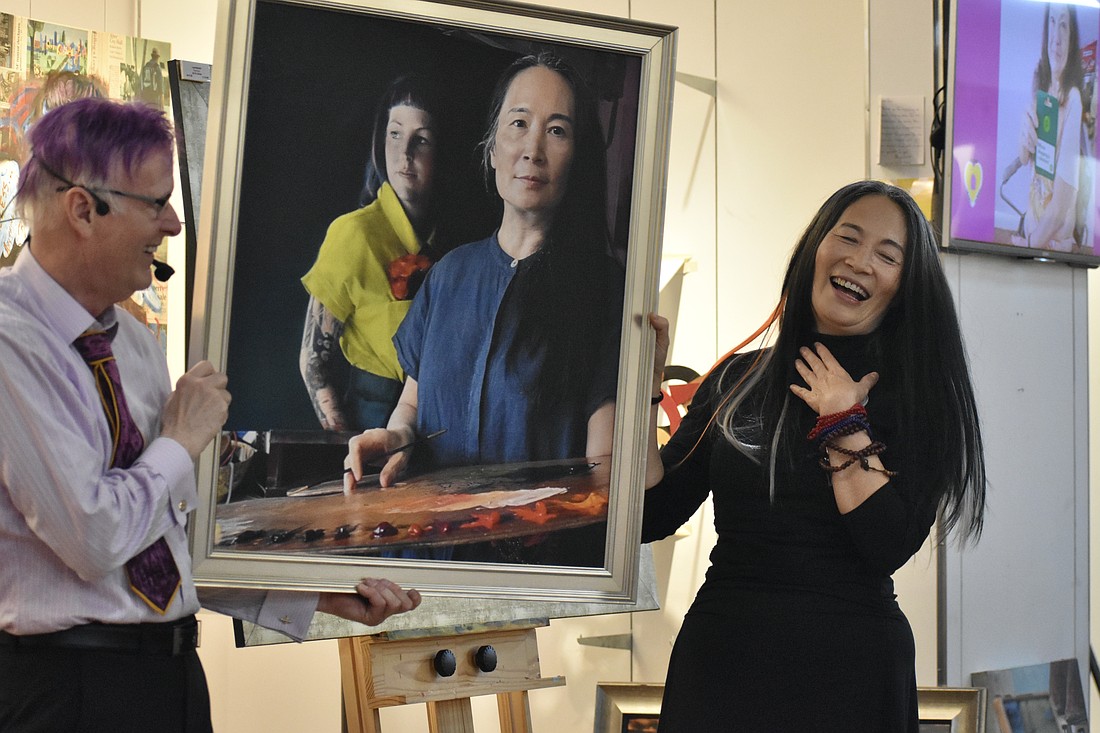 Paul Sykes presents a framed photo print of Li Jian Volk painting Megan Howell.