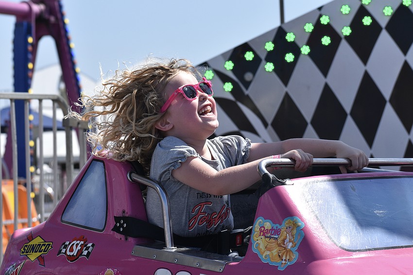 Monroe Gold, 5, rides a race car ride.