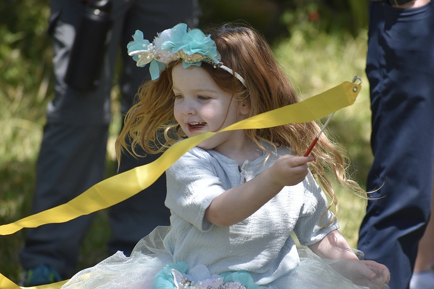 Louise Carlin, 4, plays a ribbon-waving game initiated by David Muirhead, the garden gnome.