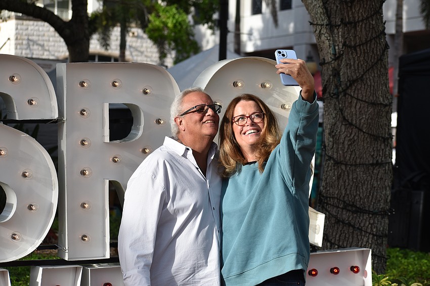 David Weinstein and his dating partner Lisa Eshkov take a selfie in front of an SRQ Wine sign.