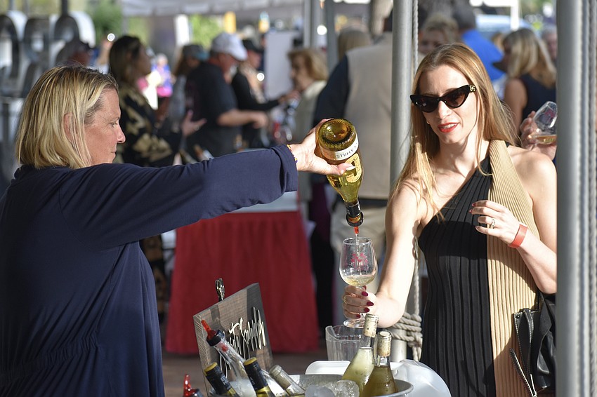 Sheley Osmond pours a wine for Karissa Campbell.