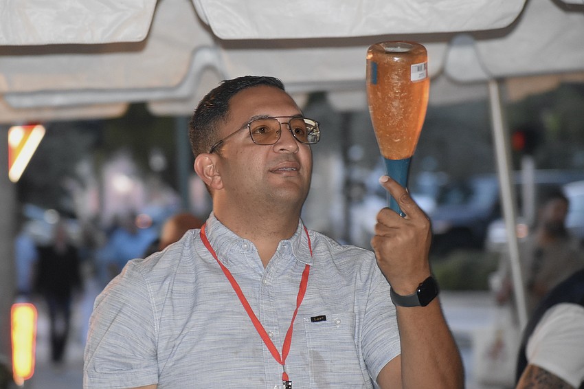 José Hernandez prepares to serve a bottle of wine.