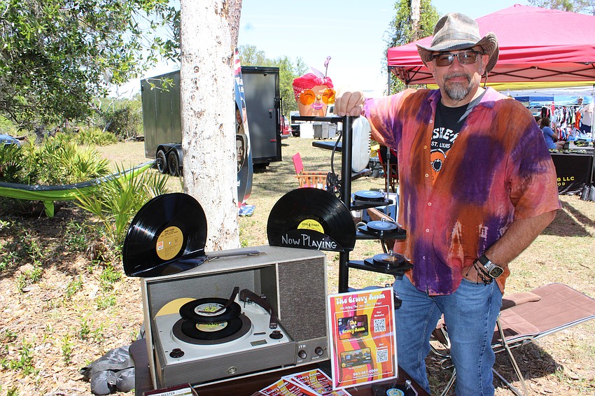 Owner Tom Schlund stands next to a vintage phonograph that was just one of the items offered at the Groovy Room that was a vendor booth at Dag Fest.