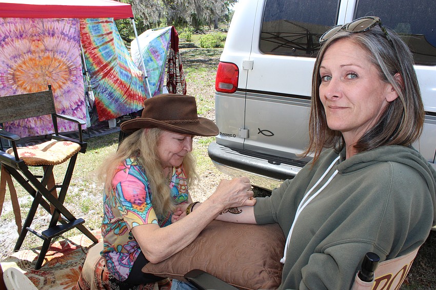 Tina Berger puts a temporary tattoo on Alicia Ackerland during Dag Fest.