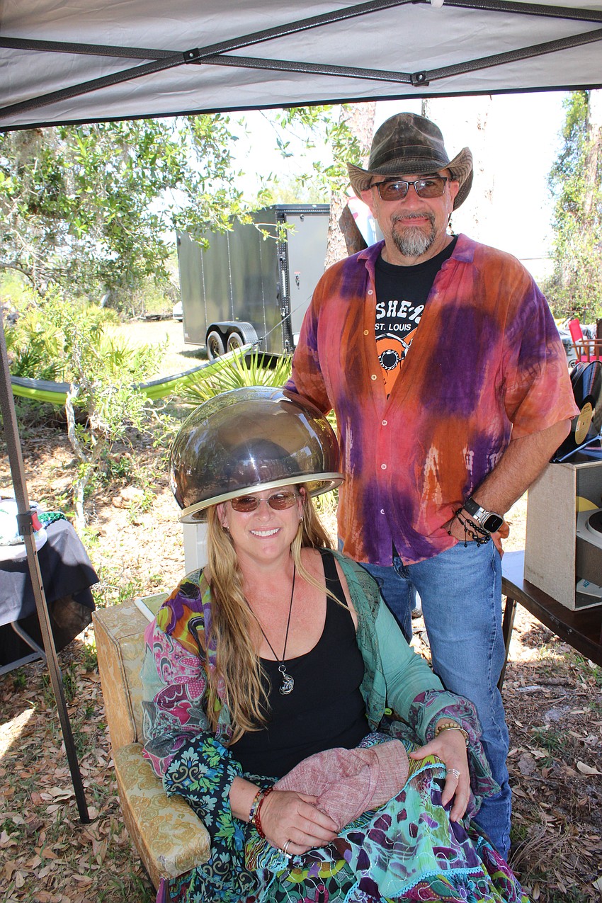 Marilyn Moss sits under a vintage hair dryer with her partner Tom Schlund behind her. The pair own The Groovy Room of Venice and had their 