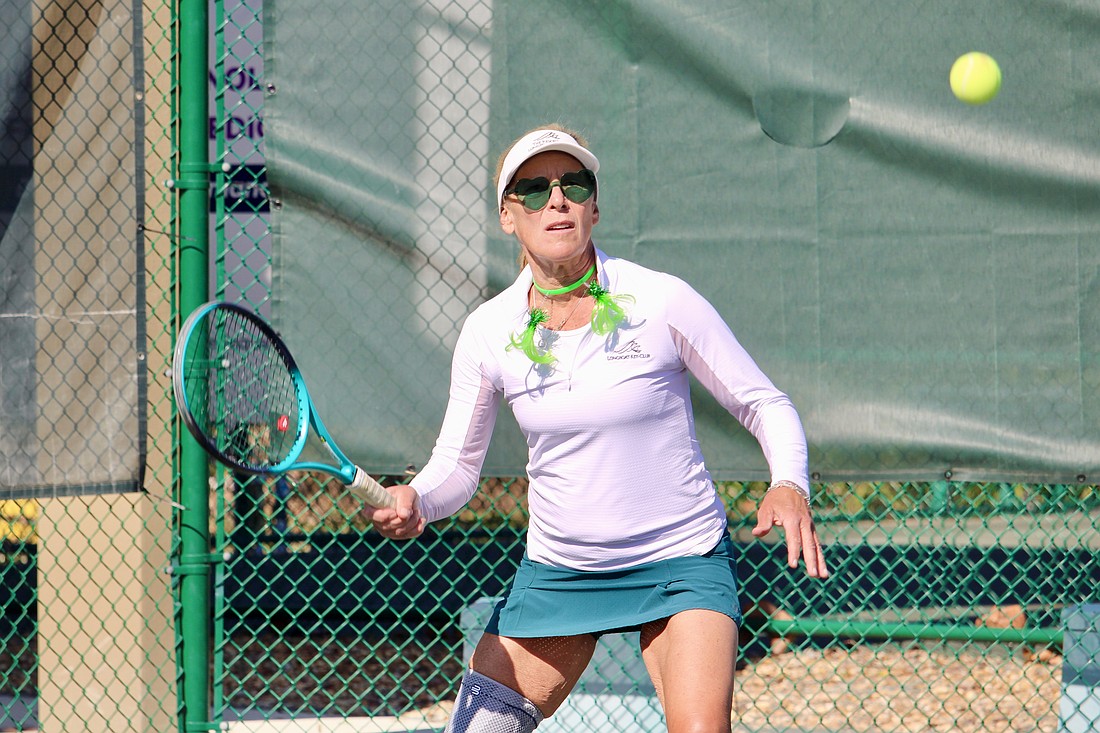 Sandra Duryea keeps her eye on the ball through shamrock sunglasses.