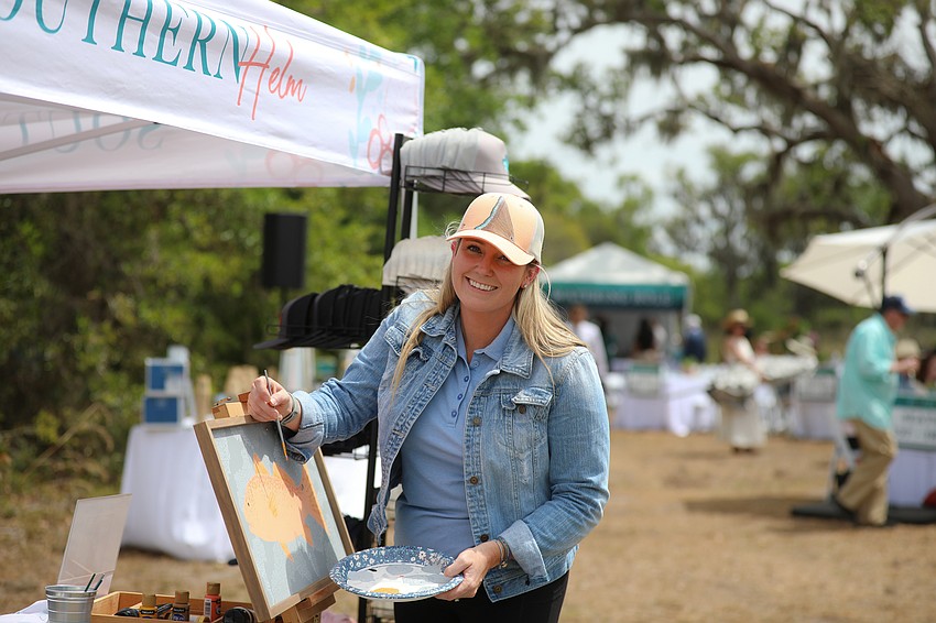 Artist Megan Van Fleet paints during the Farm to Fillet event held on March 23.