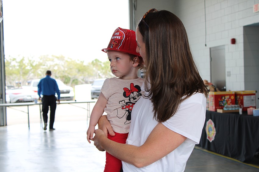Two-and-a-half-year-old Blaire Slansky checks out a big rig with Elise Kidd Slansky at the fire department open house.