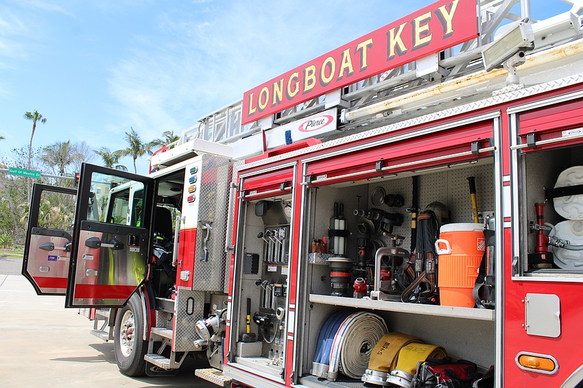 Firefighters open up the big rig to show off its equipment for visiting families.