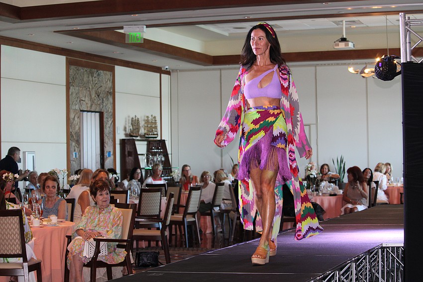 Emily Joslin starts off the fashion show with a purple swimsuit and colorful sarong.
