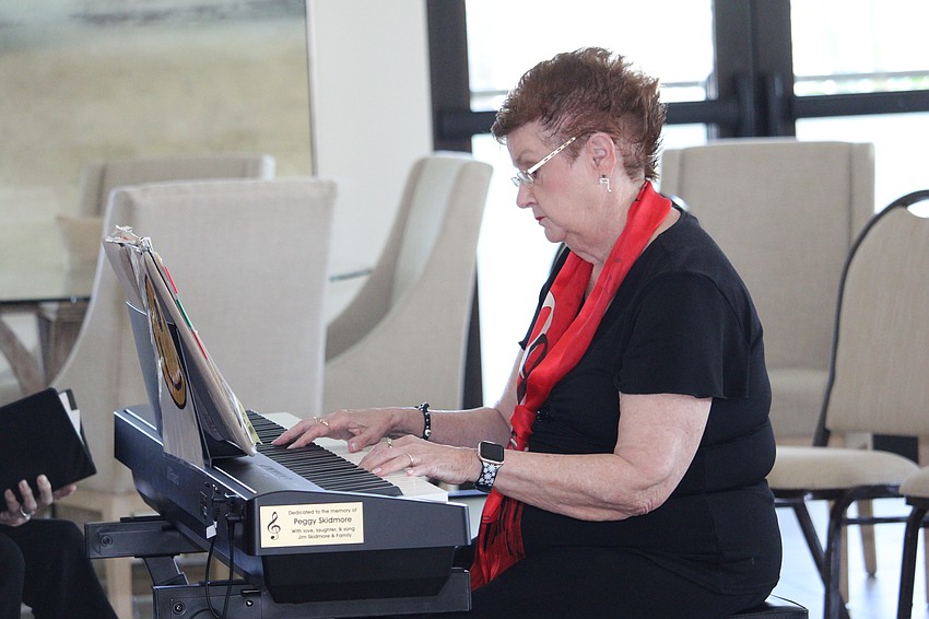 Carol Whitfield Matthews guides the singers with her piano.