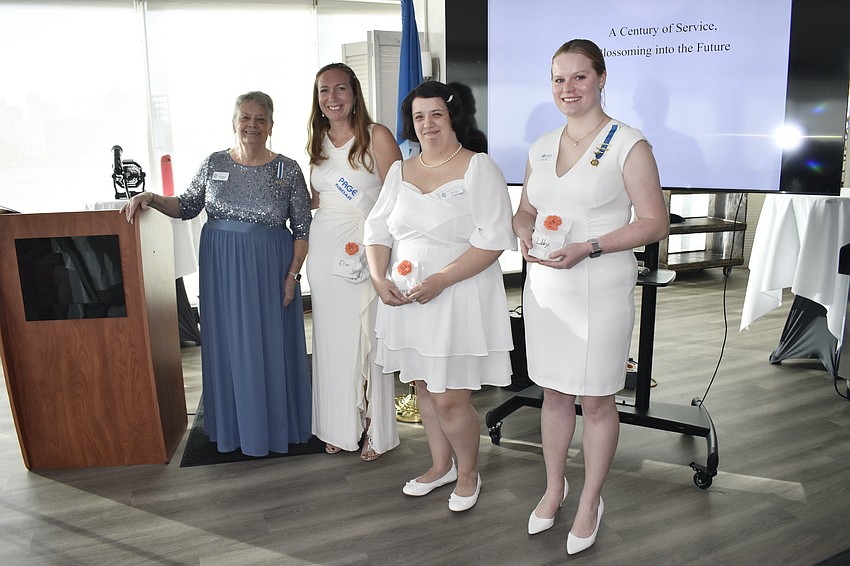 Regent Patricia Rook awards gifts to pages Erin Alton, Brooke Voyzey and Liberty Paige, club members who help with the operations.