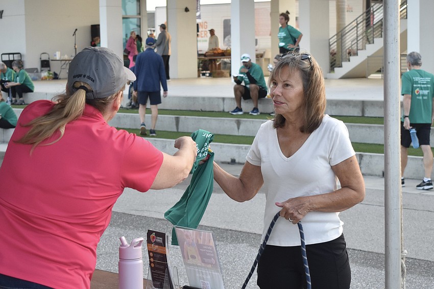 Debbie Beach hands a shirt to Anna DeFerrari.