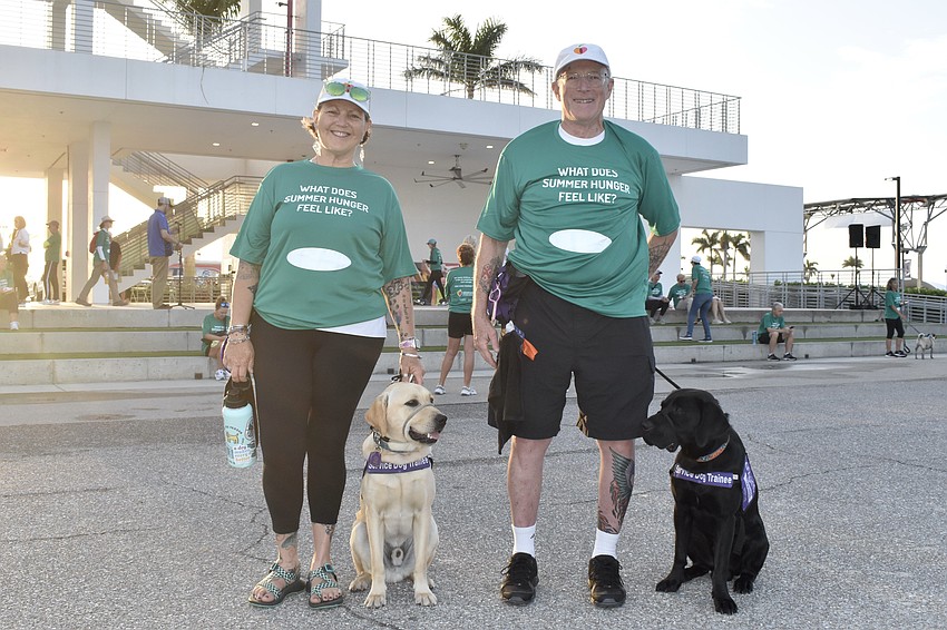 Kim and Blaine McFarlane performed volunteer duties for two organizations. They are training two Dogs Inc guide dogs, Holden and Dreamer, bringing them to different places so they can be exposed to noises and activity.