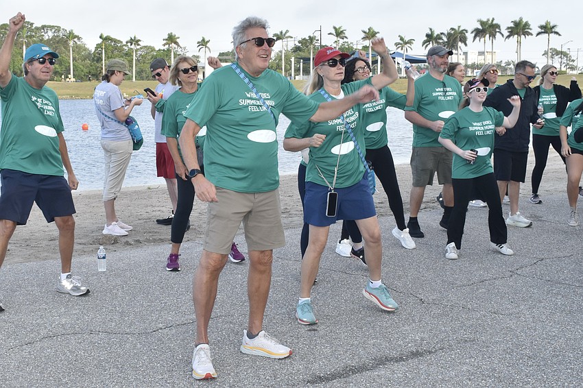 Walkers, including David and Stacy Elwart (center) perform the warmup exercises.