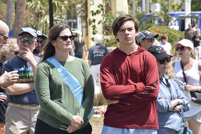 Artist Lee Hayes Byron, who is quoted in two of the artworks, and her son Evan Sellers, 15, watch an announcement.