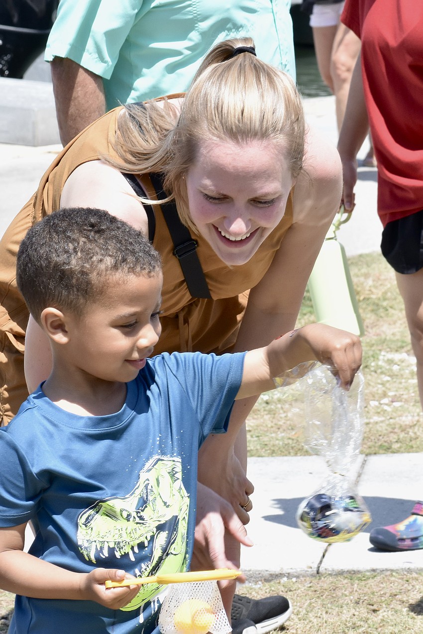 Moses Faboyede, 3, tries a fishing activity with his mother Rachel Faboyede.