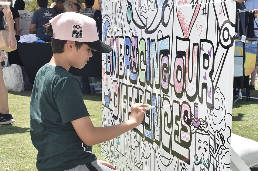 Thiago Mauri, 10, adds to a collective art piece.
