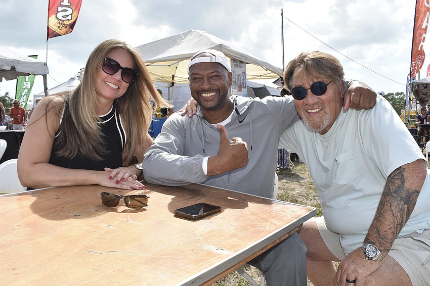 Carrie Dennison, City Commissioner Kyle Battie and festival director Bill Kinney gather at a table.