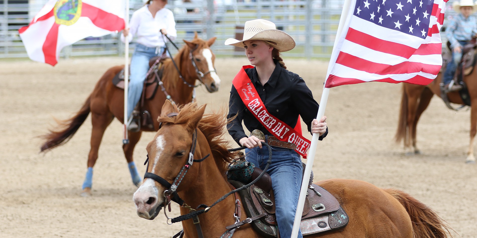 67th Cracker Day Queen (2024), Lacey Westbrook, carries the American Flag into the arena during opening ceremonies. Photo by Christine Rodenbaugh