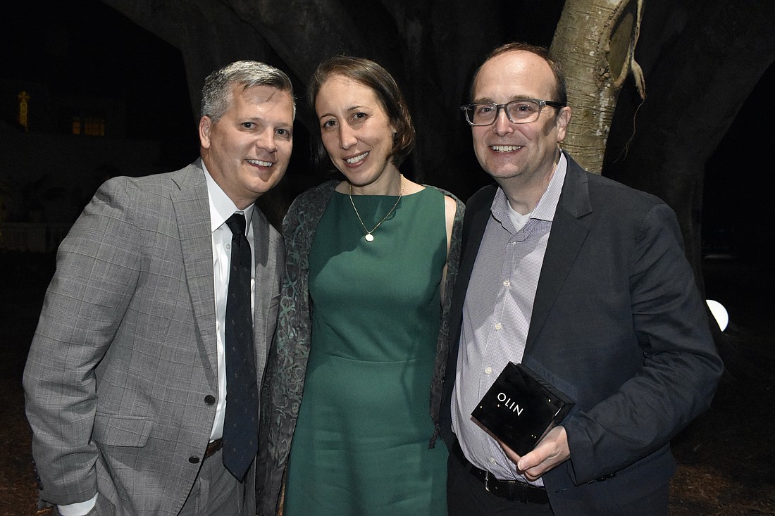 Architecture Sarasota President Marty Hylton, and Project Manager Marni Burns and Chief Purpose Officer Richard Roark of OLIN pose as Roark holds the award.