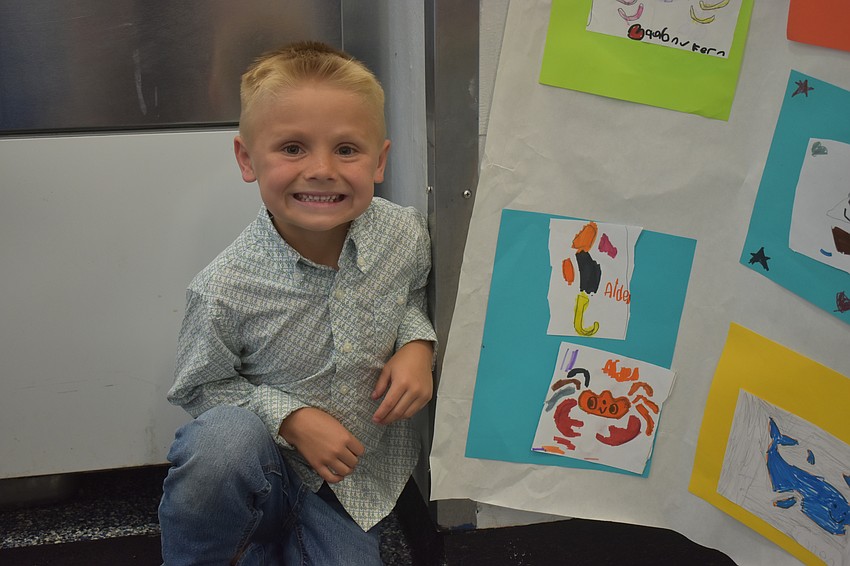 Kindergartener Aiden McClellan poses with the sea creatures he created.