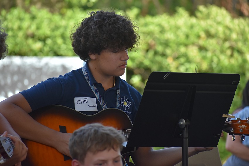 Ramses Carmona plays guitar alongside his classmates.