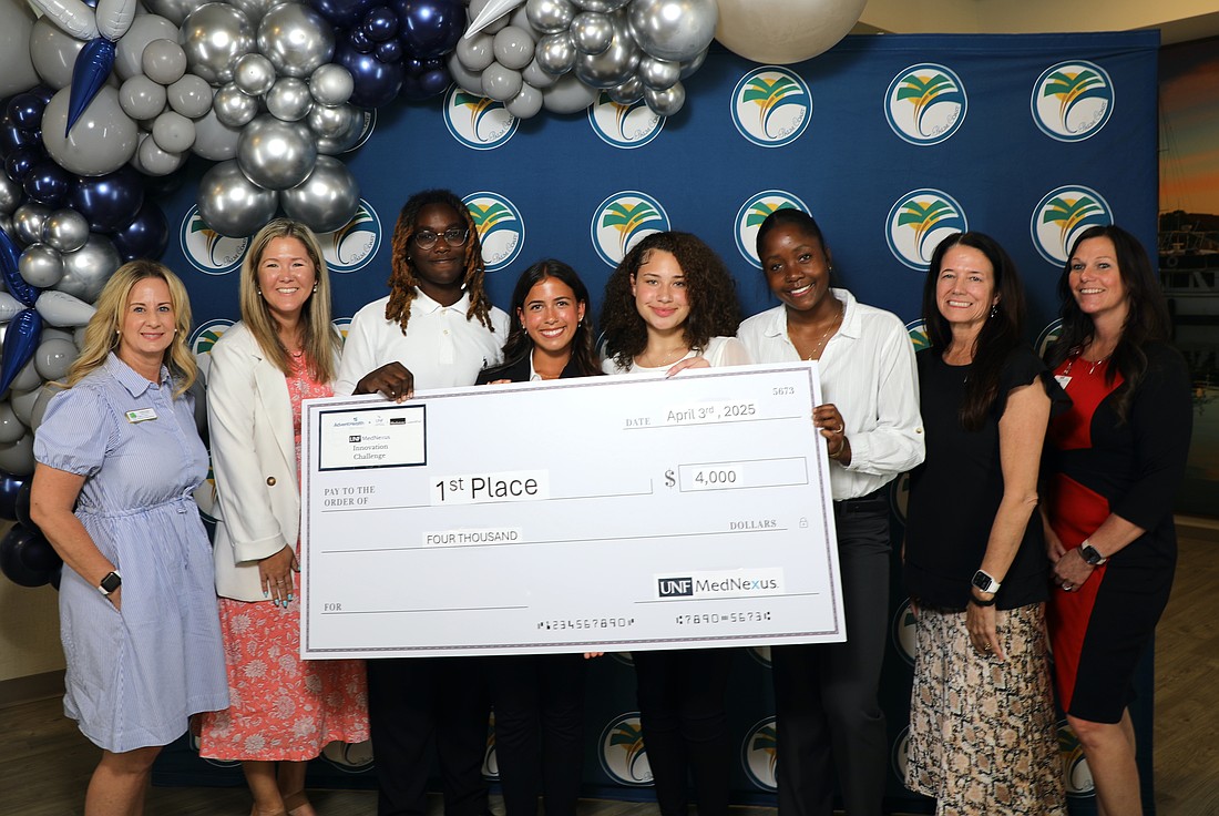 Academic Athletes Unite: Natalie Patel-Holmes, Joy Prime, Makaylla Williams and Alessandra Caballero, mentored by Dr. Rachel Achorn, took first place with each team member earning a $1,000 scholarship. At left, Flagler County Education Foundation Executive Director Teresa Rizzo and Palm Coast Acting City Manager Lauren Johnson. Courtesy photo