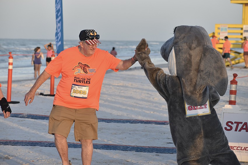 Keep Morse slaps hands with Mote's mascot Gilly.