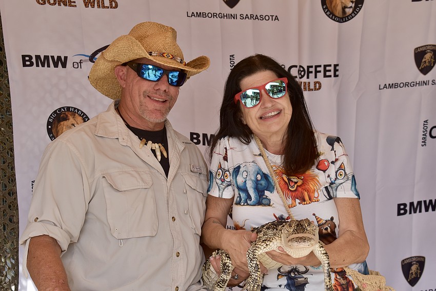 John Kenyon lets Sarasota's Shari Muska hold a hypomelanistic American alligator.